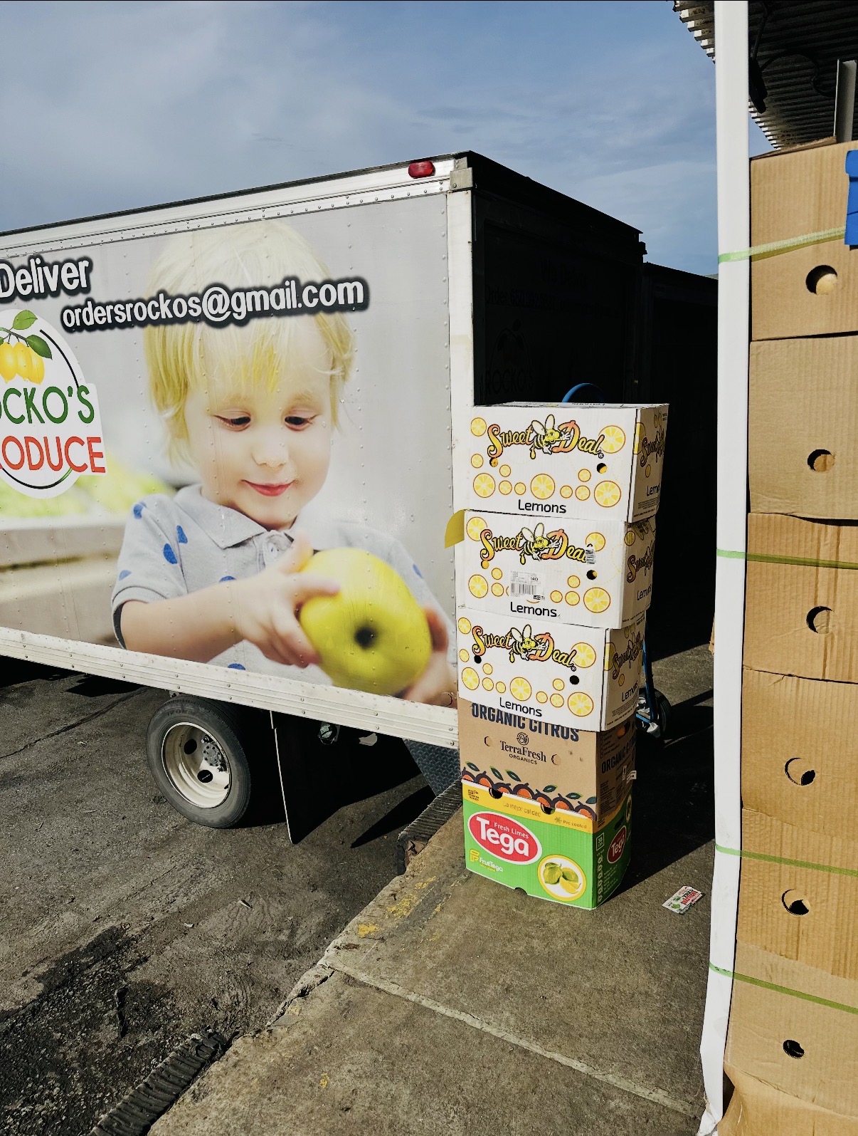 Rocko's Produce delivery truck alongside boxes of citrus at the market